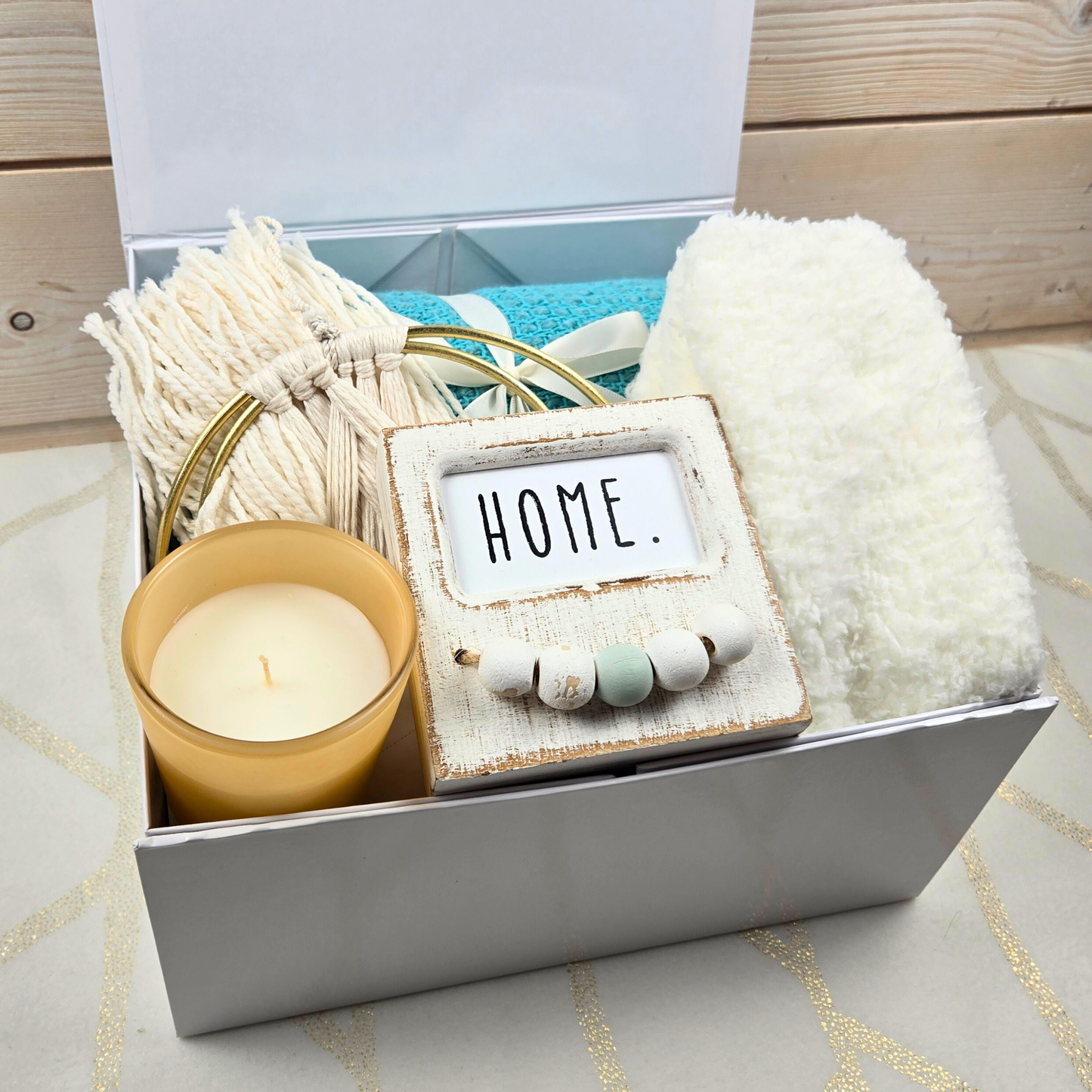 Boho-style gift box for her with decor, throw, fuzzy socks and candle.