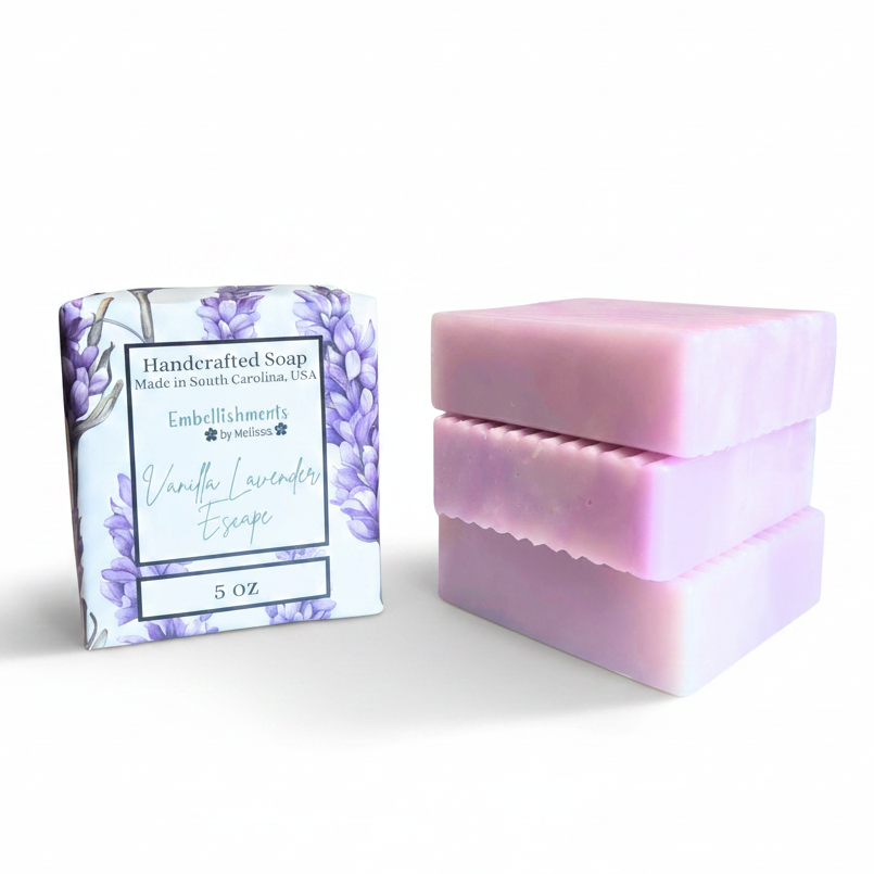 Three lavender-colored handcrafted soap bars next to their decorative package, which features a purple floral pattern and reads 'Vanilla Lavender Escape.'