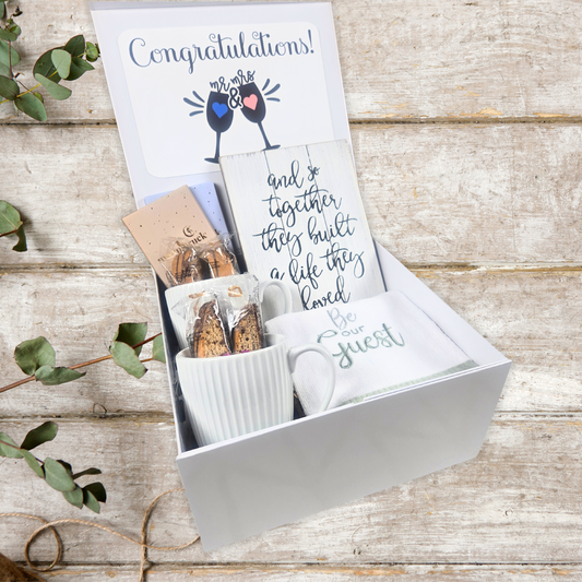 Wedding gift box with wedding sign, hand towel, 2 mugs, 4 biscotti, milk chocolate bar and dark chocolate bar.