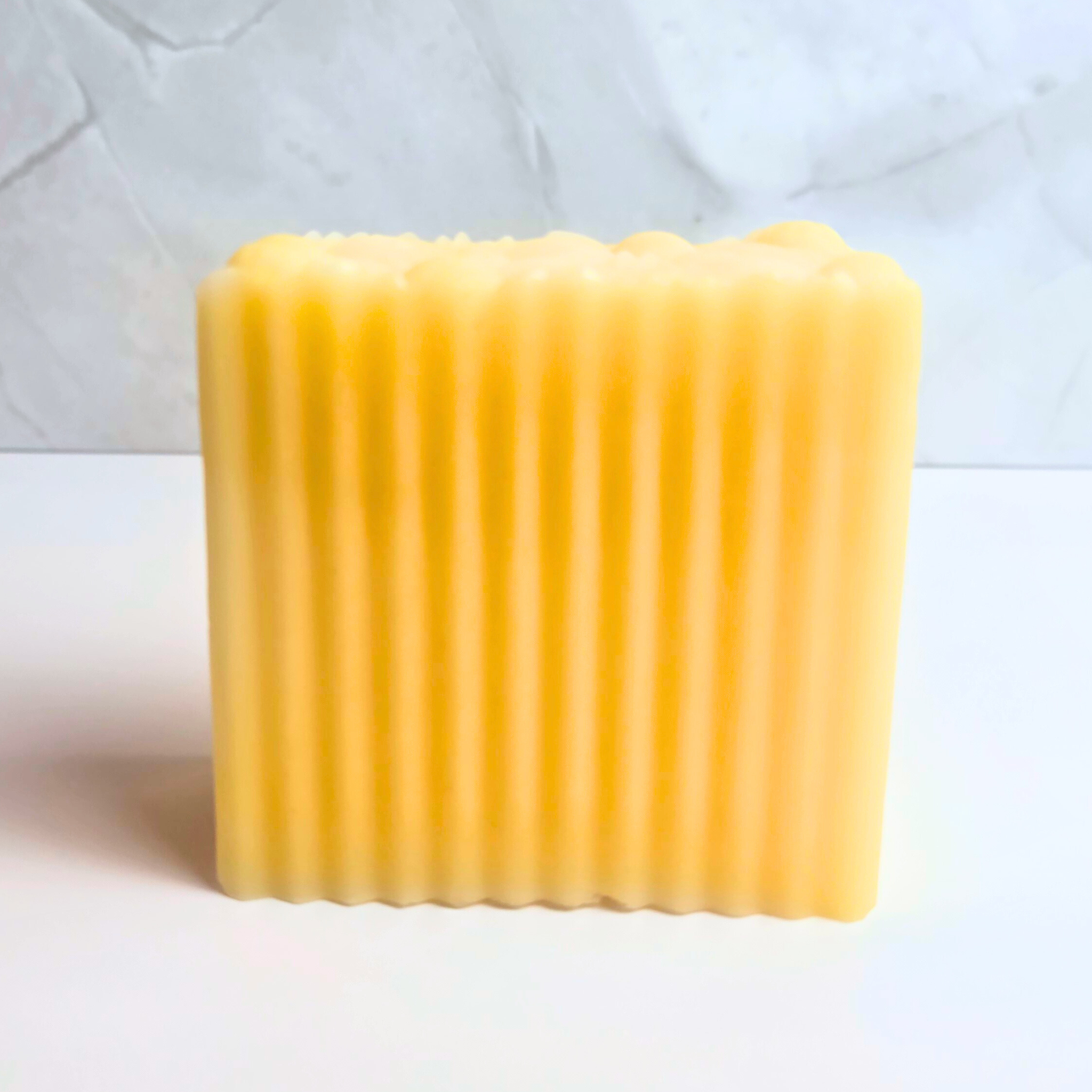 Yellow soap bar with zesty lemon aroma, aemrtisan-made, front view.